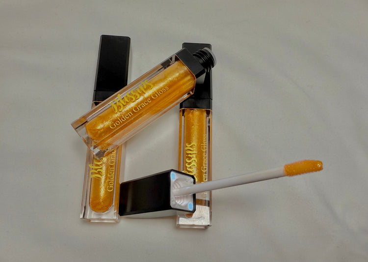 Our Golden Grace LED Lip Gloss is a smooth, moisturizing gold shine with a built-in LED light for precise application. It features a sleek tube with the Blessips logo and a mirror.